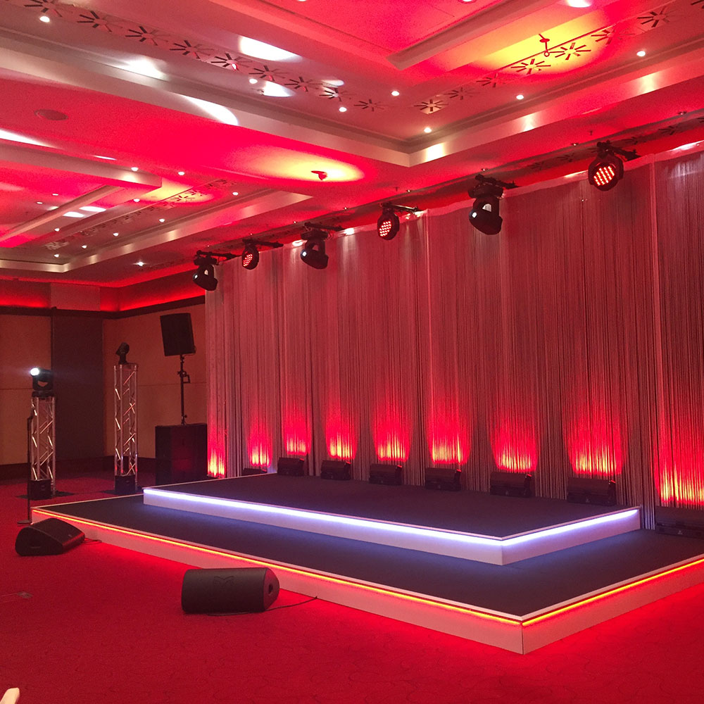 Bühnenbau mit Stufenbeleuchtung und Fadenvorhang rot illuminiert